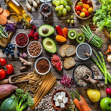 Vegan food backgrounds: large group of multicolored fresh fruits, vegetables, cereals and spices shot from above on wooden background. The composition includes green apple, kiwi, pear, pomegranate, orange, coconut, banana, grape, berries, ginger, almonds, pistachio, olive oil, olives, goji berries, chia seeds, pinto beans, nutmeg, rosemary, radish, tomatoes, carrot, kale, avocado, onion, rice, cocoa powder, sweet potato, wholegrain pasta, tofu, lettuce, corn, broccoli, pepper, asparagus, green beans, among others. High resolution 42Mp studio digital capture taken with SONY A7rII and Zeiss Batis 40mm F2.0 CF lens